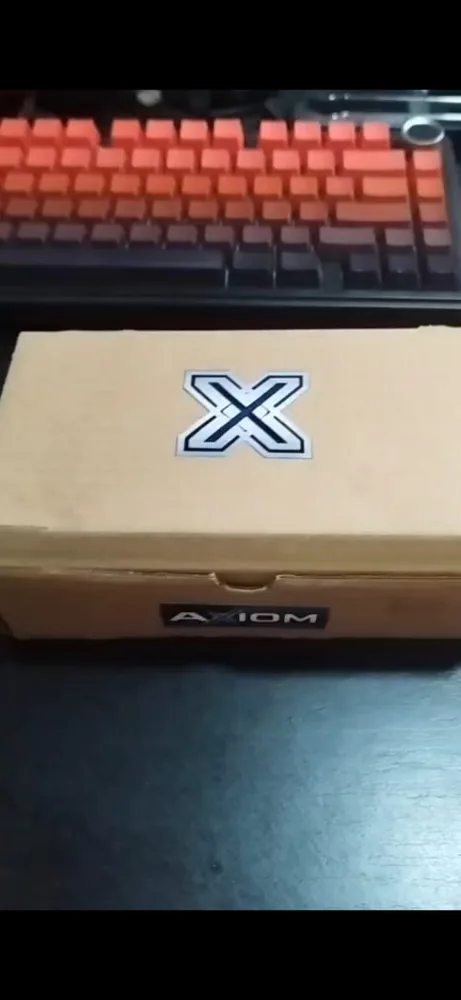 Caixa de papelão da Axiom Systems com o logo X, pronta para envio